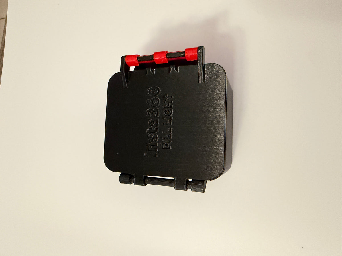 Top view of the black carrying case showing the hinged lid and red latch.
